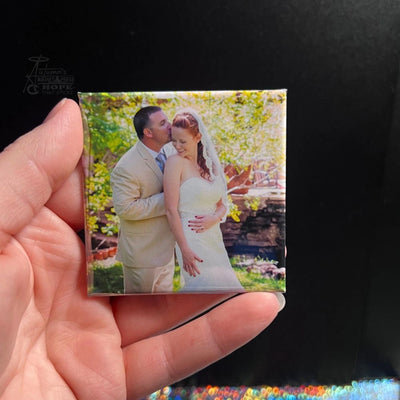 Hand holding a rectangular photo magnet of a bride and groom on their wedding day, representing lasting love and celebration from Autumn’s Magnet Press.