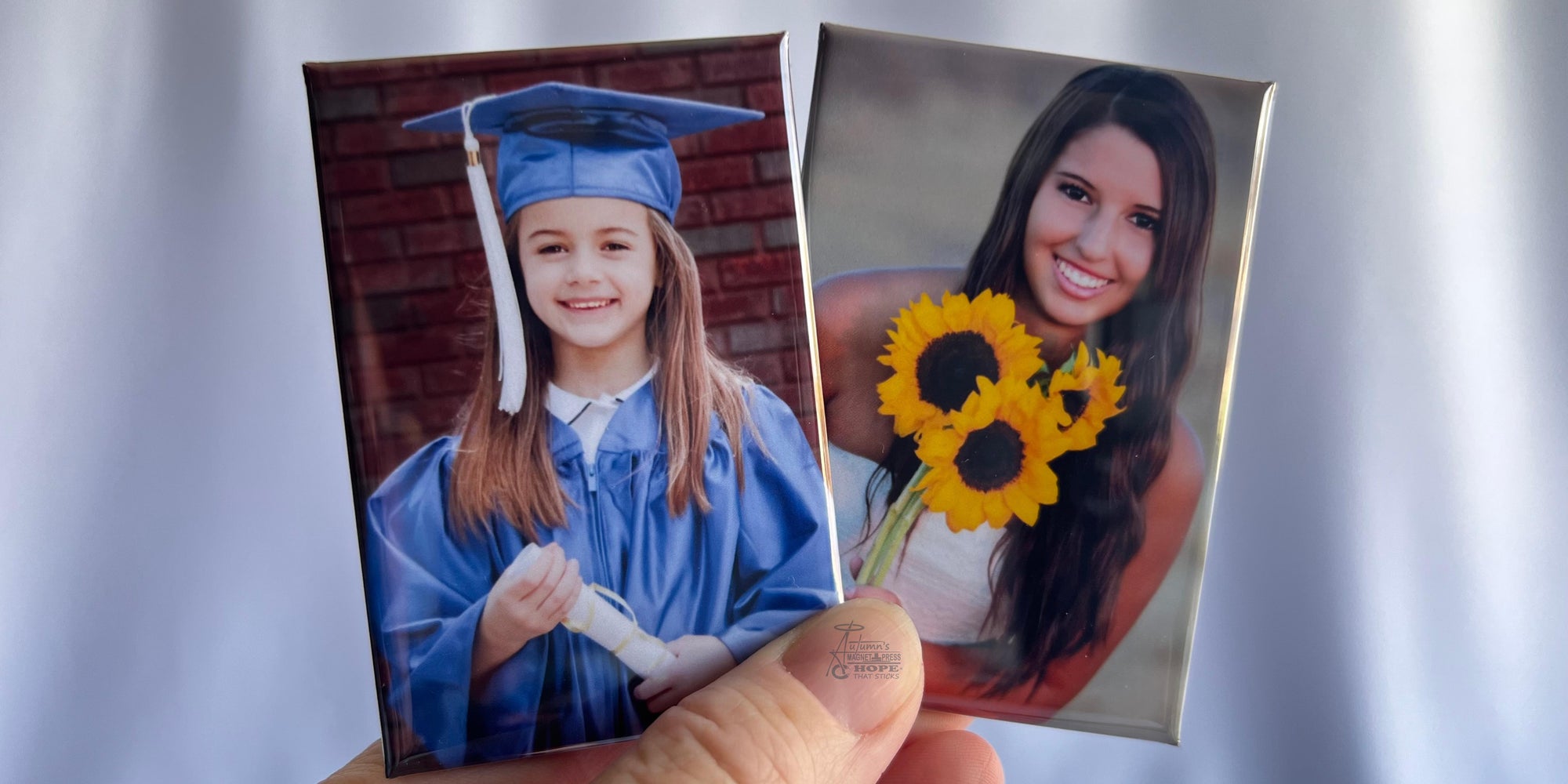 Two custom graduation photo magnets showing a young graduate and senior portrait held side by side against a soft white background.