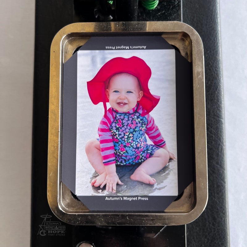 Custom baby photo magnet template loaded into an Autumn’s Magnet Press machine during the magnet making process.