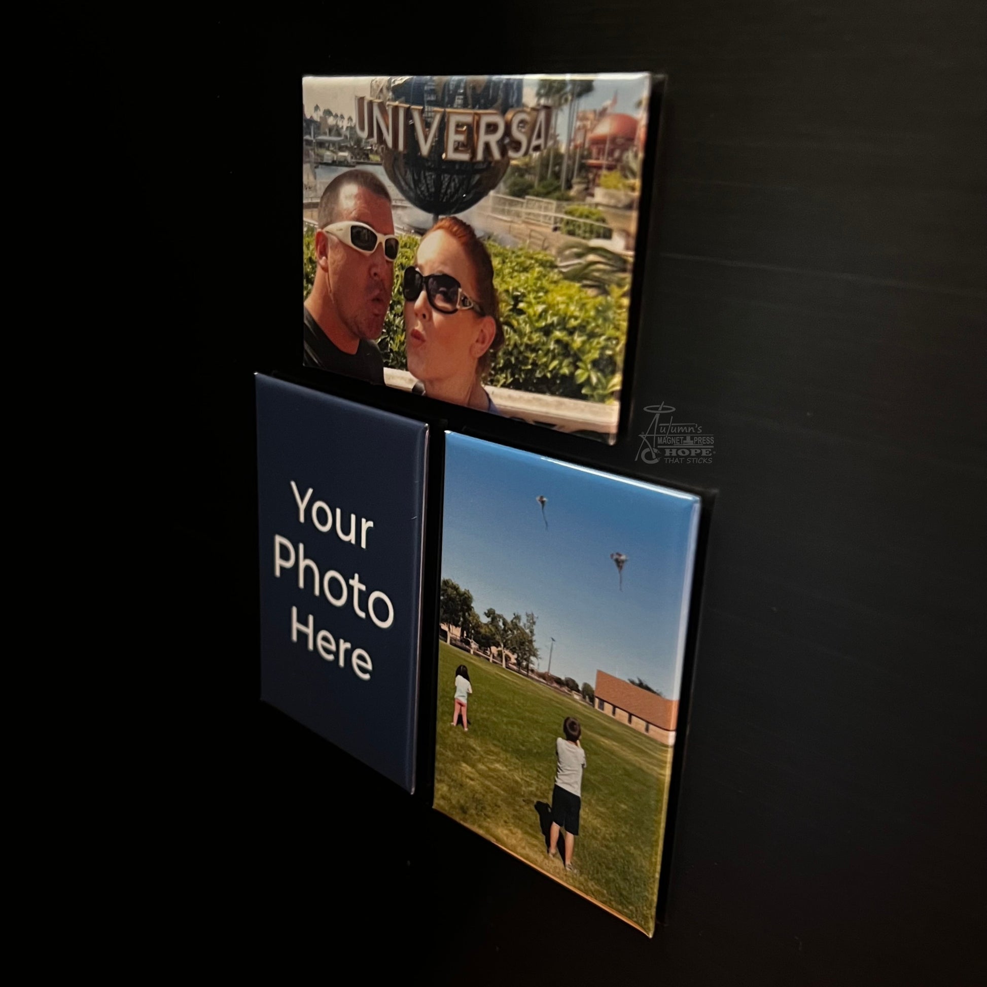 Set of 3 rectangle custom photo magnets with family and travel photos on a dark metal surface