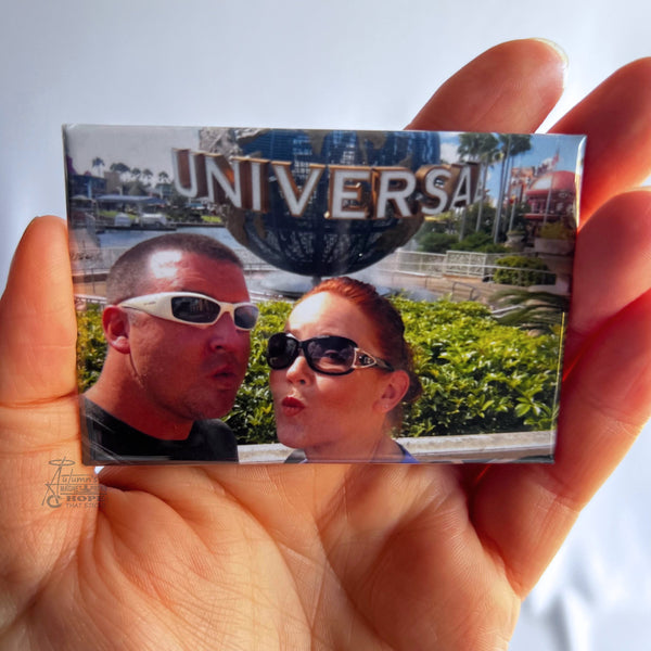 Custom travel photo magnet featuring a couple at Universal Orlando holding a vacation memory from their theme park trip.