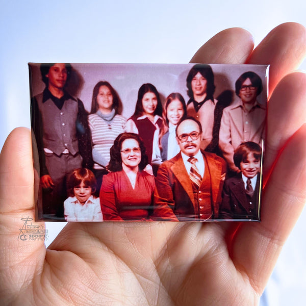 Hand holding a custom vintage family photo magnet featuring a large family portrait against a soft white background